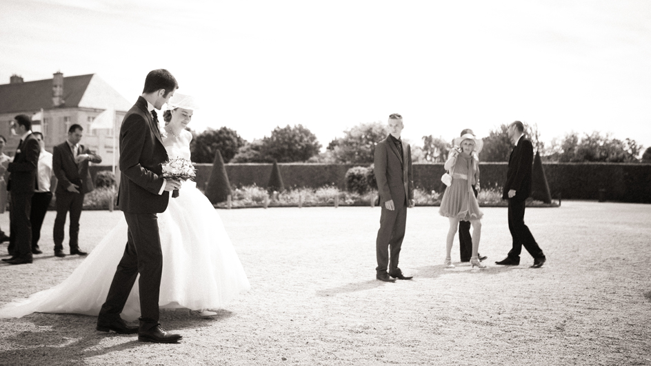 Photographe mariage Caen : Les mariés marchant à la mairie de Caen avec leurs invités